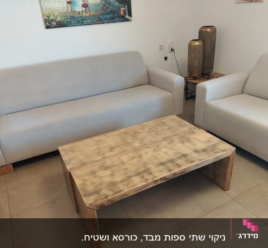 שתי ספות בהירות ושולחן עץ בסלון